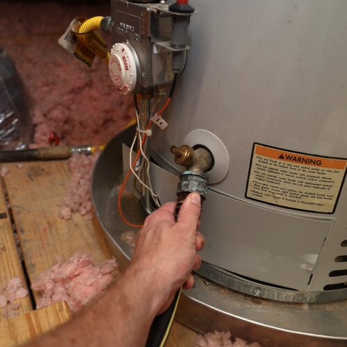 hose being attached to a traditional water heater