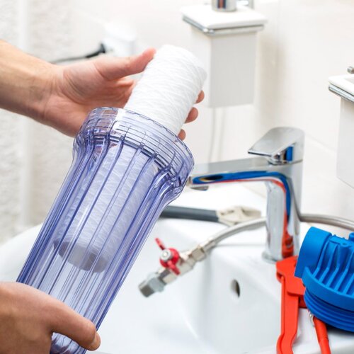 close-up of a plumber installing a water filtration system