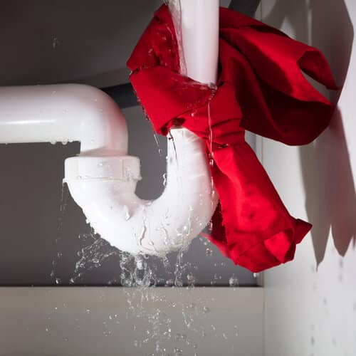 red napkin tied around a burst pipe