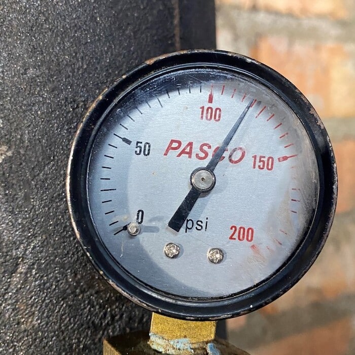 Water pressure booster depicted with brick background